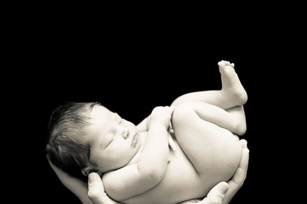 Exchanging Fear for Truth Newborn held in the hands of her father.