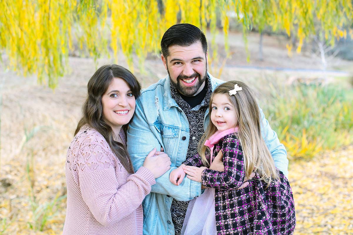 The author standing with her husband and oldest daughter under a tree